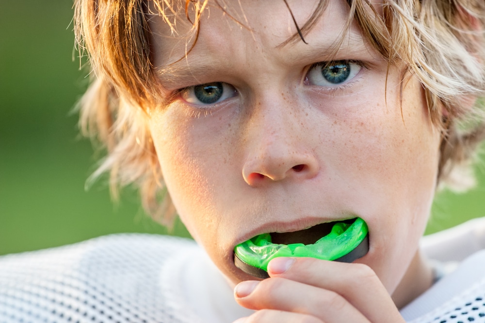 boy putting athletic mouth guard in mouth